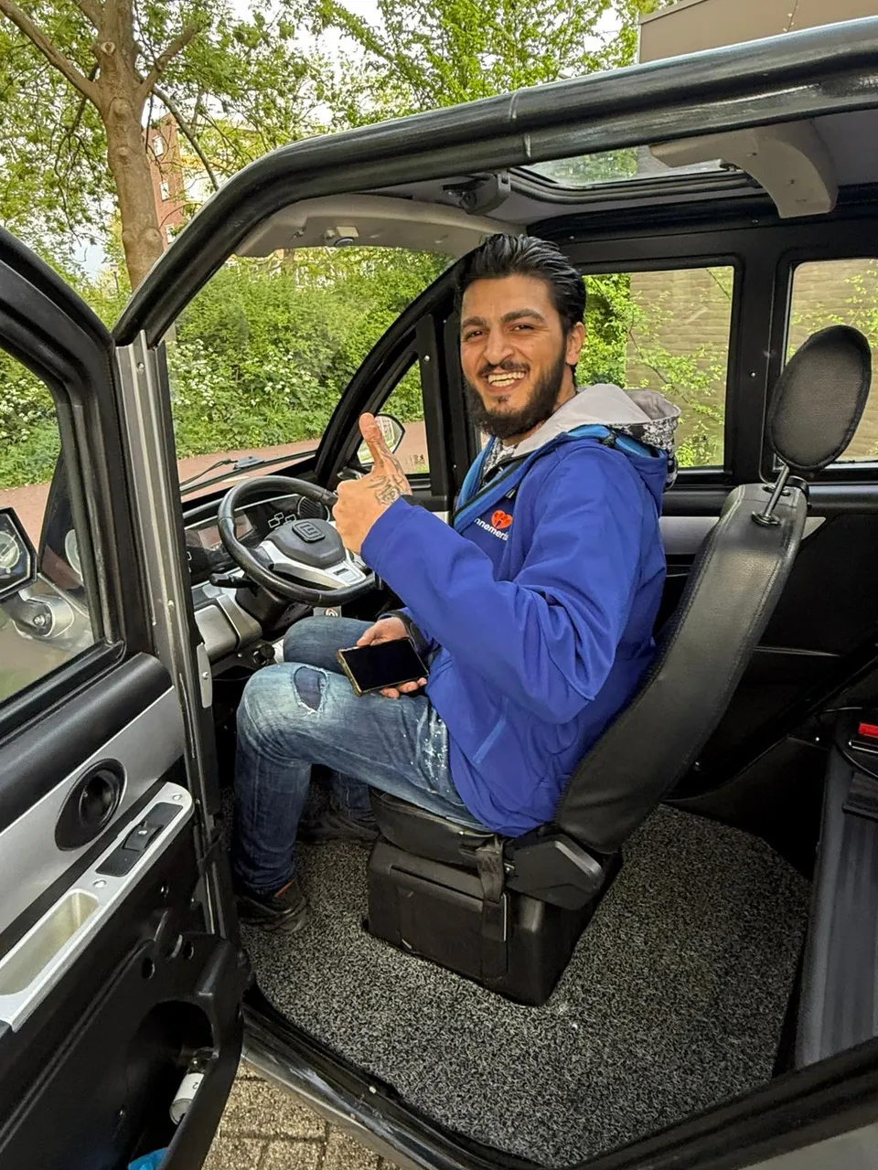 Happy Voltron customer back behind the wheel of his microcar after an on-spot tyre replacement in Amsterdam