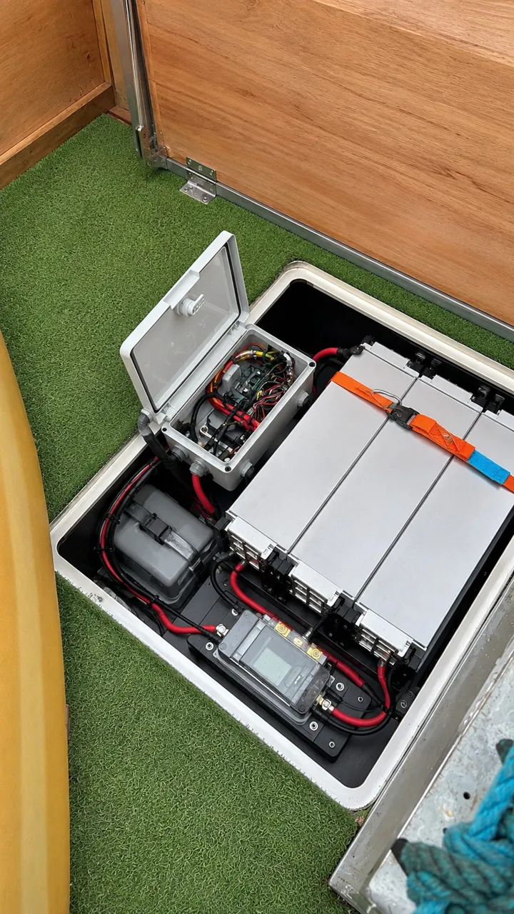 Drie IP-gekeurde NMC-modules onder een batterijluik — Voltron BMS, shunt en hoofdschakelaar